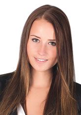 Junge Frau kann lachend in einen Apfel beissen